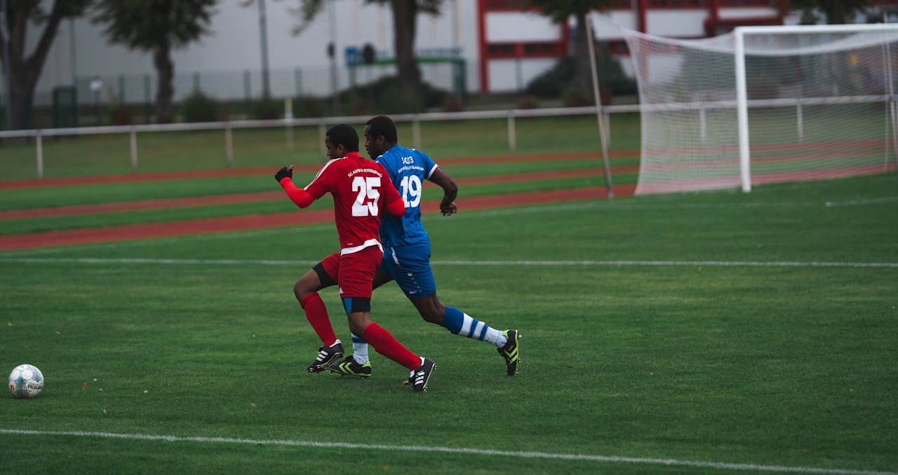 Players in action on a soccer field, chasing the ball during a match.